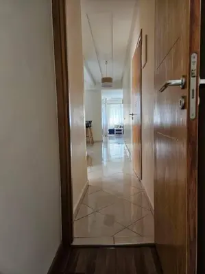 a hallway with a wooden door and a room with a table at Bel appartement en bord de mer in Casablanca