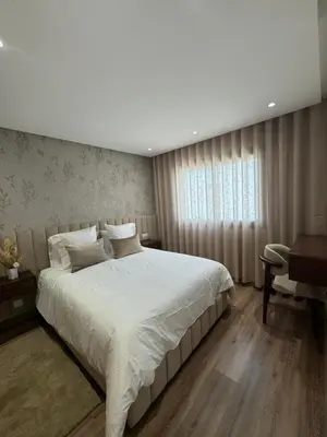 a bedroom with a large white bed and a desk at au cœur de la Corniche in Casablanca