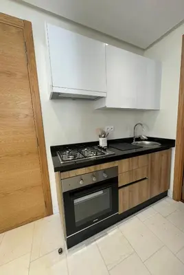 a kitchen with a stove and white cabinets at au cœur de la Corniche in Casablanca