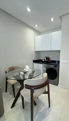 a kitchen with a glass table and a dining room at au cœur de la Corniche in Casablanca