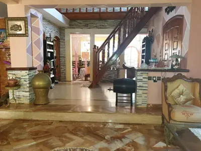 a living room with a staircase and a chair at Villa entièrement meublée à louer à Mohammedia in Mohammedia