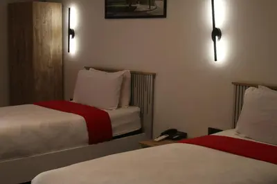 a hotel room with two beds with white and red sheets at The Hotel Syracuse in Casablanca