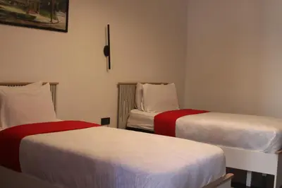 a room with two beds with red and white sheets at The Hotel Syracuse in Casablanca