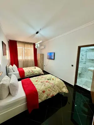 a bedroom with two beds and a window at The Hotel Syracuse in Casablanca