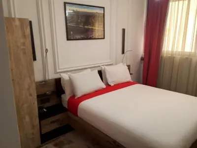 a bedroom with a white bed with a red blanket at The Hotel Syracuse in Casablanca