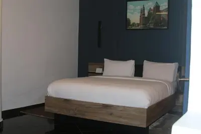 a bed with white sheets and pillows in a room at The Hotel Syracuse in Casablanca
