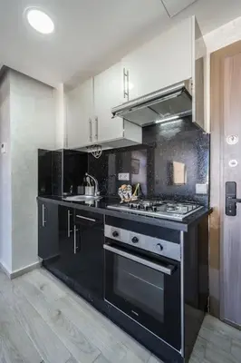a kitchen with a black and white stove top oven at Stylish Studio à Ain Sebaa in Casablanca
