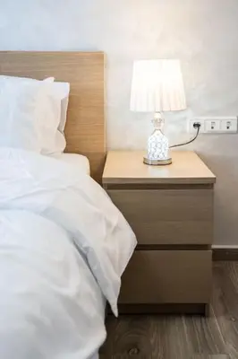 a bed with a night stand with a lamp on it at Stylish Studio à Ain Sebaa in Casablanca
