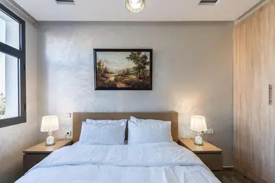 a bedroom with a large bed with two lamps on tables at Stylish Studio à Ain Sebaa in Casablanca