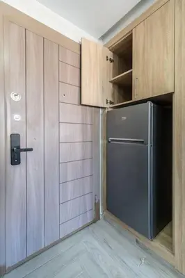 a kitchen with a refrigerator and wooden cabinets at Chic Apartment Cosy Stay in Casablanca