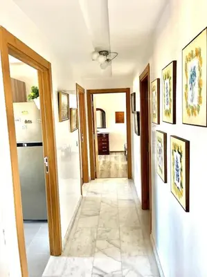 a hallway leading to a kitchen with a refrigerator at Miramar Luxury apartment Front Beach View in Mohammedia