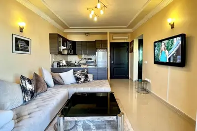 a living room with a couch and a tv on a wall at Fabulous Apartment Beach view in Mohammedia