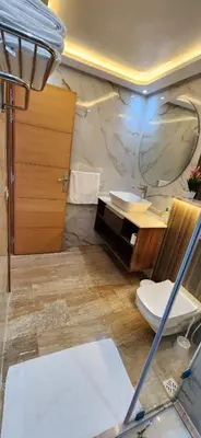 a bathroom with a sink and a toilet and a mirror at Beautiful beachfront apartment in Rabat
