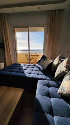 a bedroom with two beds and a large window at Beautiful beachfront apartment in Rabat
