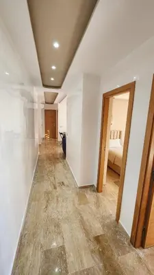 a room with white walls and a hallway with a bed at Beautiful beachfront apartment in Rabat