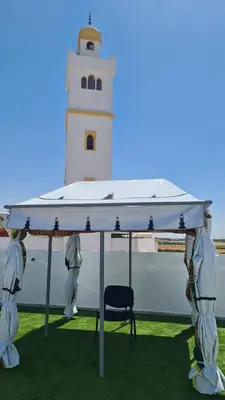 a lighthouse with a chair in front of it at Camping on the rooftop close to Casablanca Airport in Dah Hammou Ben Cheïkh