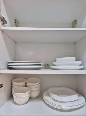 a shelf filled with white plates and bowls at My Cosy Place - Apartment 2BR - Piscine - Bahia Beach - Bouznika in Bouznika