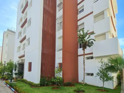 a building with a red column on it at Bel appartement 5 min de Stade Prince Moulay Abdellah in Rabat