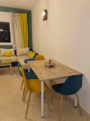 a living room with a wooden table and chairs at Bel appartement 5 min de Stade Prince Moulay Abdellah in Rabat