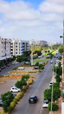a city street with cars parked in a parking lot at Bel appartement 5 min de Stade Prince Moulay Abdellah in Rabat