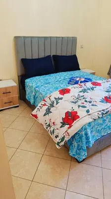 a bedroom with a bed with a floral bedspread at appartamento in residenza protetta con piscina in Mohammedia