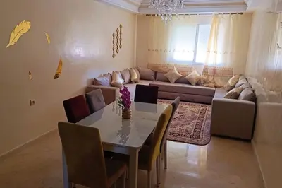 a living room with a table and a couch at appartamento in residenza protetta con piscina in Mohammedia