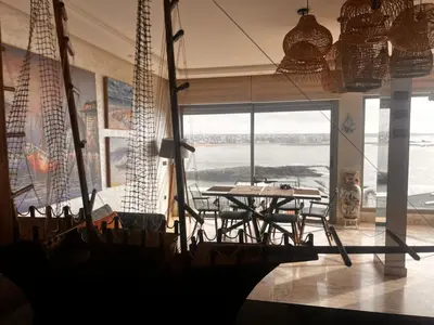 a large room with a table and a large window at Appartement vue sur mer résidence Les vagues des sablettes Mansouria in Mohammedia