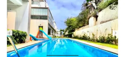 a swimming pool with a slide in front of a building at Appartement vue sur mer résidence Les vagues des sablettes Mansouria in Mohammedia