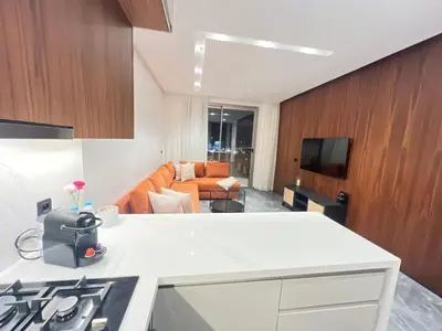 a kitchen with a white counter and a living room at Casa finance city - Anfa Park - CFC in Casablanca