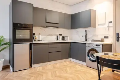 a kitchen with gray cabinets and a dishwasher at Cozy Luxurious Bourgogne Studio in Casablanca