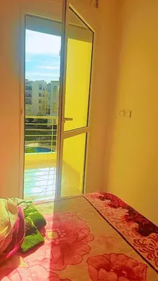 a bedroom with a bed with a view of a balcony at Bouznika in Bouznika
