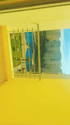 a yellow window with a view of a building at Bouznika in Bouznika