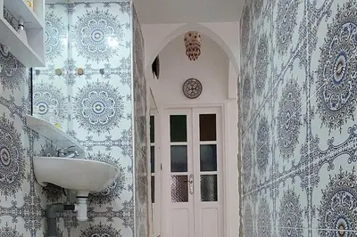 a bathroom with a sink and blue and white wallpaper at Taddart, Maison de vacances in Temara