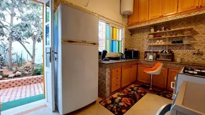 a kitchen with a white refrigerator and a window at Taddart, Maison de vacances in Temara