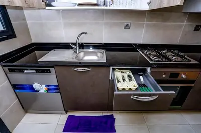 a small kitchen with a sink and a stove at Moderne et luxueux in Rabat