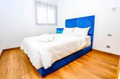 a large bed with a blue headboard in a room at Moderne et luxueux in Rabat
