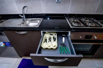 a kitchen with a sink and a drawer with utensils at Moderne et luxueux in Rabat