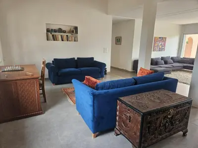 a living room with blue couches and a table at Premium farmhouse with pool in Rabat