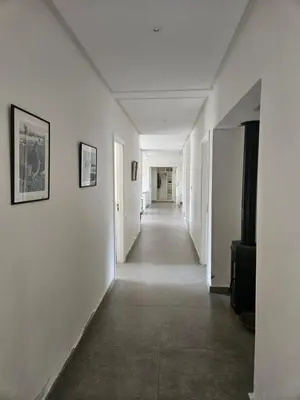an empty hallway with white walls and a long corridor at Premium farmhouse with pool in Rabat