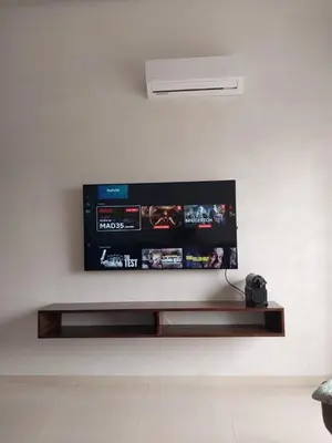 a flat screen tv hanging on a wall at Vacances Soleil Piscine & Plage Bouznika in Bouznika