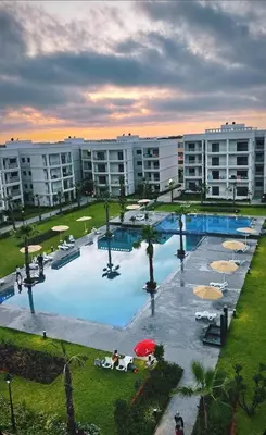 a large swimming pool with umbrellas in a resort at Vacances Soleil Piscine & Plage Bouznika in Bouznika