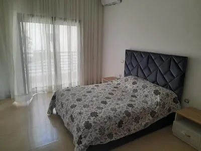 a bedroom with a bed with a black and gray bedspread at Vacances Soleil Piscine & Plage Bouznika in Bouznika