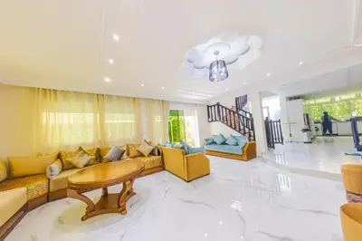 a living room with a couch and a table at Villa en bord de plage, située dans une résidence à El Mansouria, idéale pour une grande famille ou pour des personnes seules in Mansouria