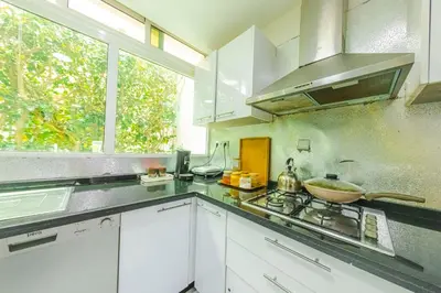 a kitchen with white cabinets and a sink and a window at Villa en bord de plage, située dans une résidence à El Mansouria, idéale pour une grande famille ou pour des personnes seules in Mansouria