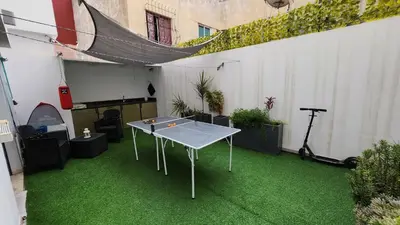 a ping pong table in a patio with green grass at Sunny apartment with terrace near CasaFiananceCity in Casablanca