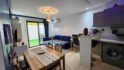 a kitchen and living room with a table and a couch at Sunny apartment with terrace near CasaFiananceCity in Casablanca