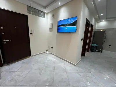a room with a television on a wall at Appartement spacieux et calme à proximité de la mer et la gare agdal in Rabat