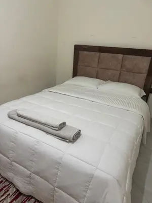 a white bed with a towel on top of it at Appartement spacieux et calme à proximité de la mer et la gare agdal in Rabat