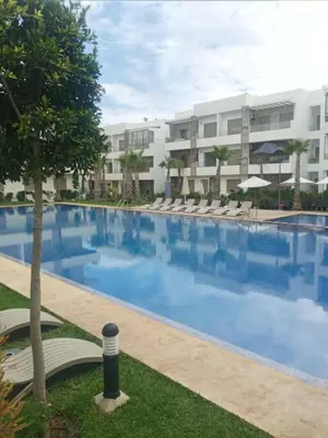 a large swimming pool in front of a building at Heaven Beach Front Apartment 2 Br in Sidi Rahal