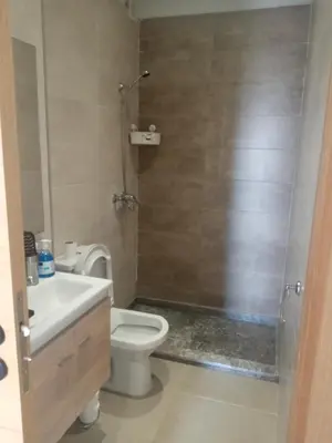 a bathroom with a toilet and a sink and a shower at Heaven Beach Front Apartment 2 Br in Sidi Rahal
